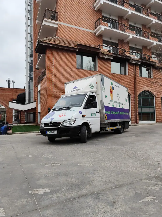 Autoutilitară pregătită pentru transport lângă un imobil